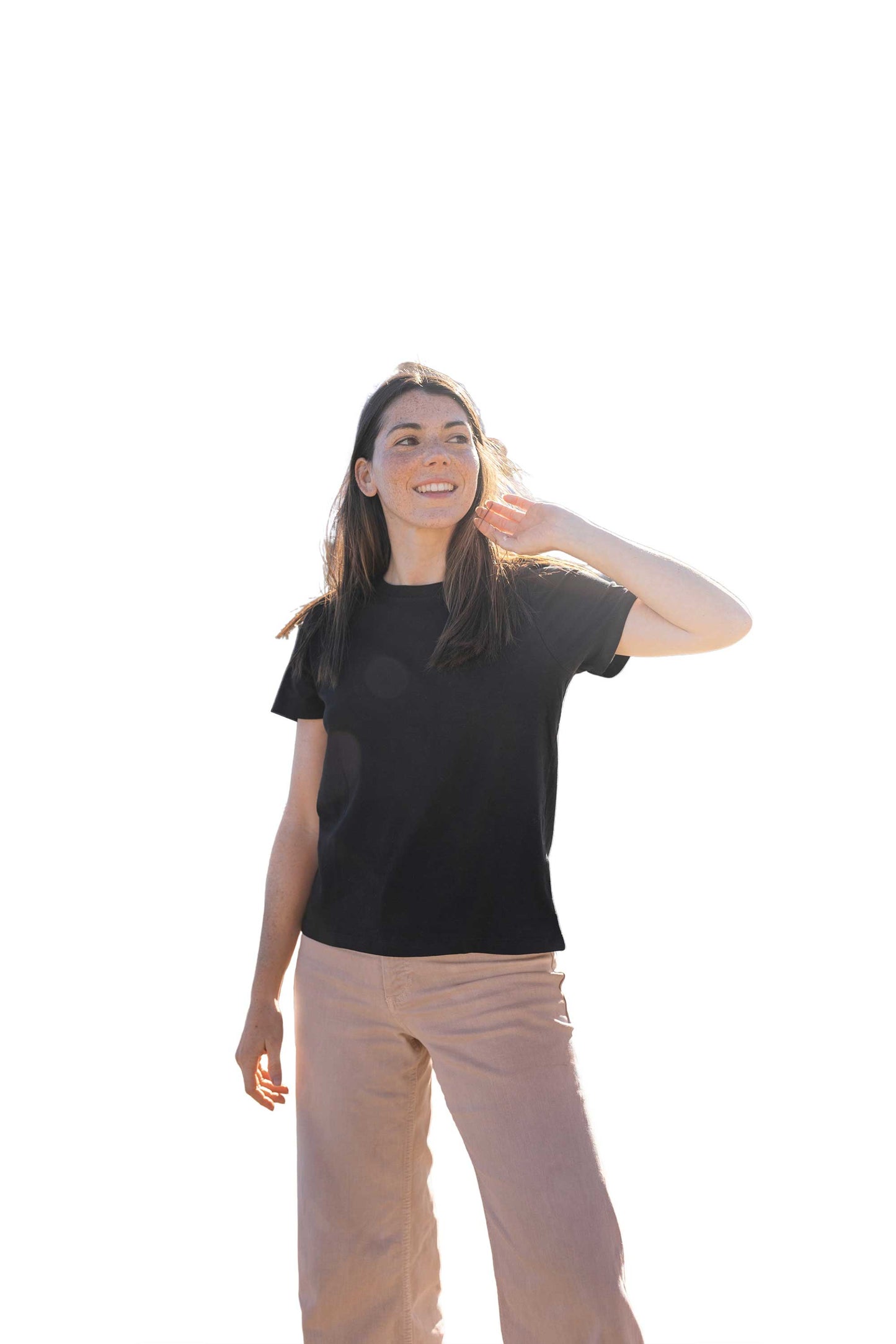Person wearing a black t-shirt and beige pants on a white background