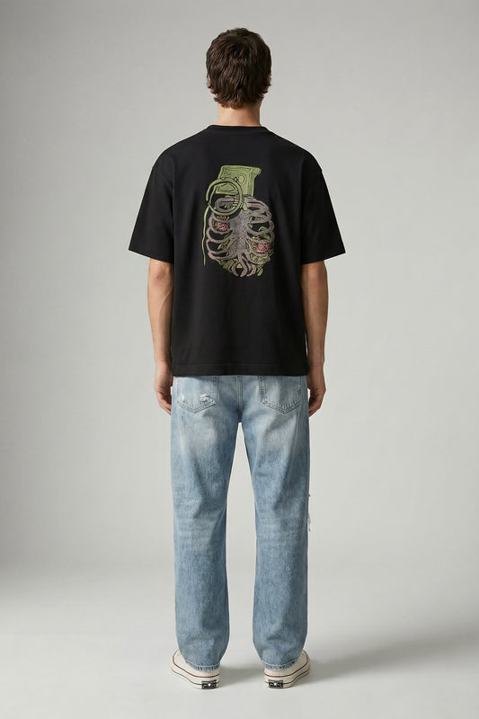 Person wearing a black t-shirt with a graphic design on the back and light blue jeans, standing against a plain background.