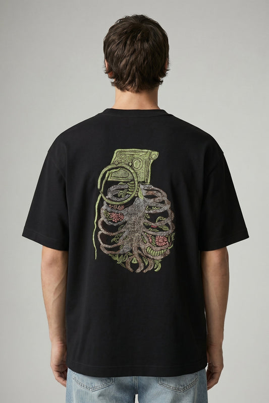 Person wearing a black t-shirt with a graphic design on the back against a gray background