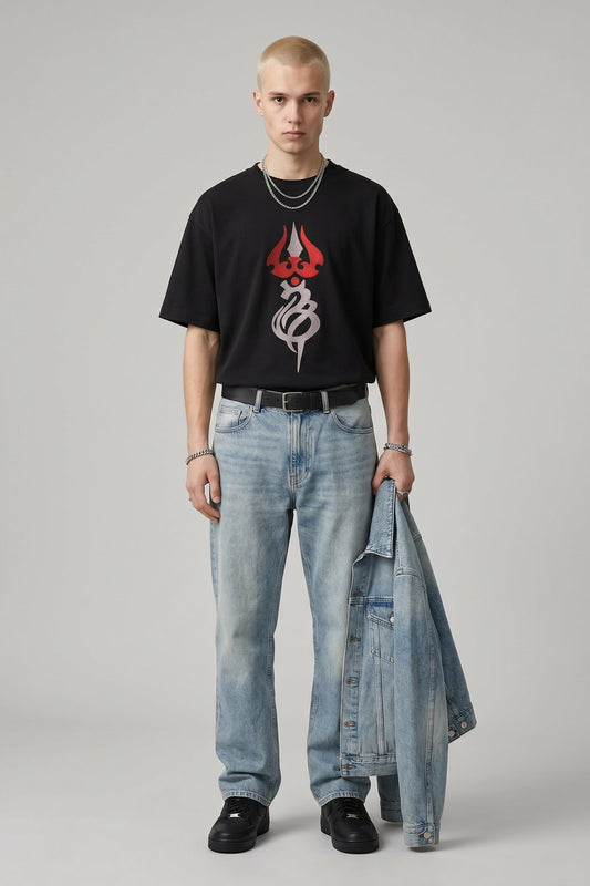 Person wearing a black t-shirt with a red and white logo and light blue jeans on a gray background