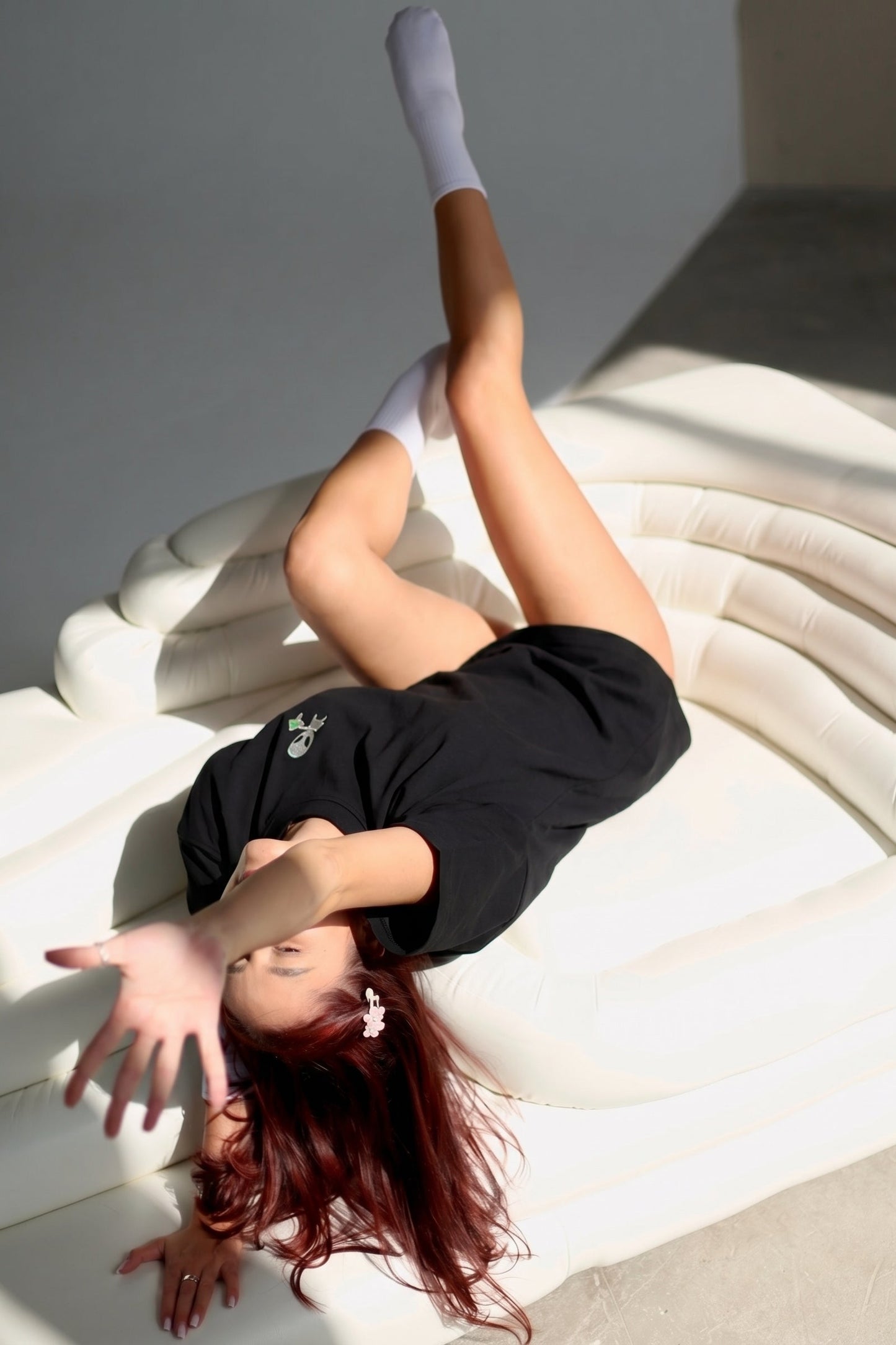 Person lying on a white surface with a neutral background